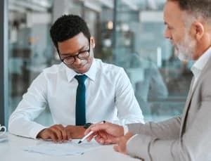 Hands placing coins into a glass jar as a savings habit